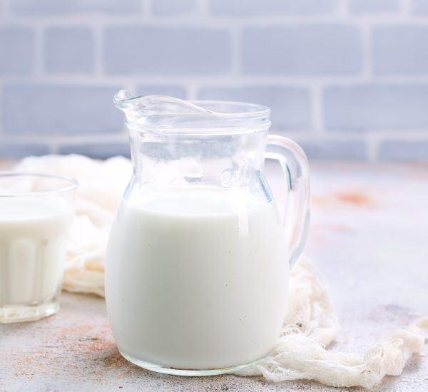 fresh milk in glass and jug on a table